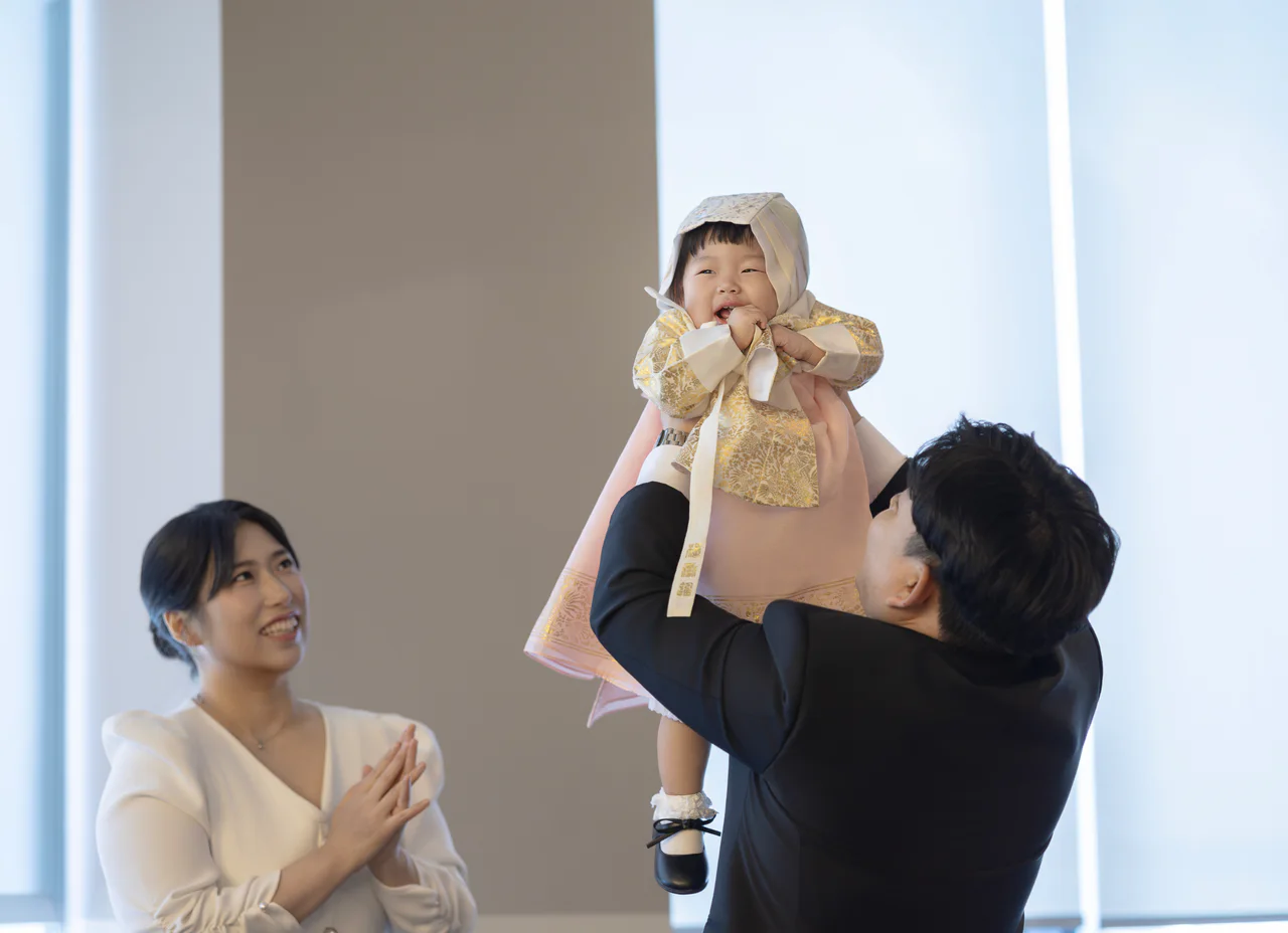 신라스테이 동탄 돌잔치에서 아이를 들어 올리며 함께 웃는 가족
